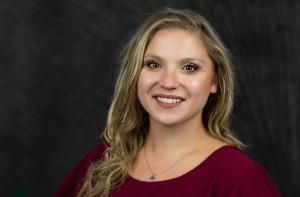 A white female psychologist-in-training who is smiling